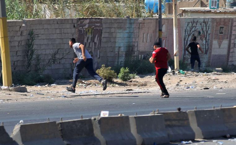 Iraqi protesters run during demonstration against state corruption and failing public services
