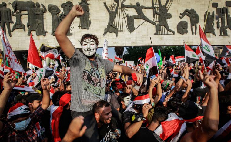 Iraqi people wave flags and shout slogans during an anti-government demonstration at Tahrir Square, Baghdad