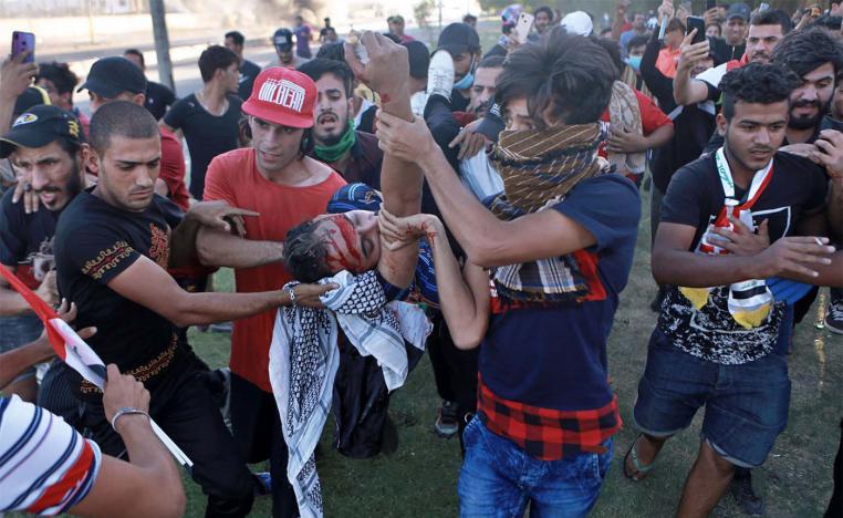 An injured protestor is rushed to the hospital after being shot during a demonstration in Baghdad