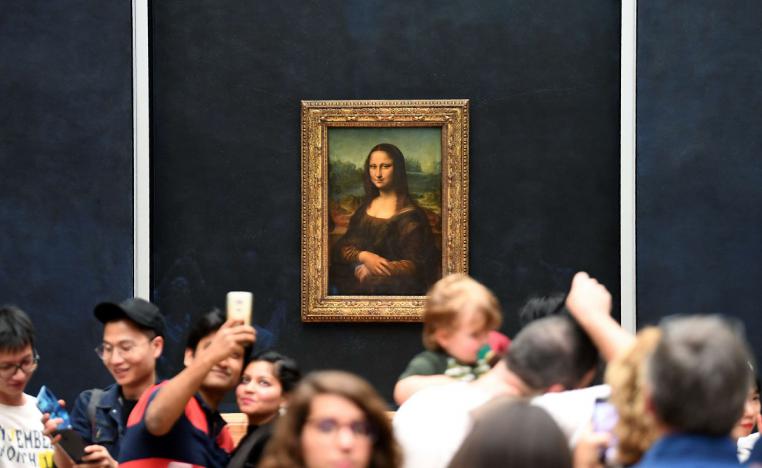 زوار يلتقطون صورا مع لوحة الموناليزا