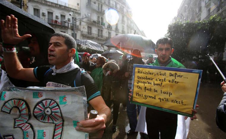 Demonstrators march under heavy rain during a protest against the country's ruling elite