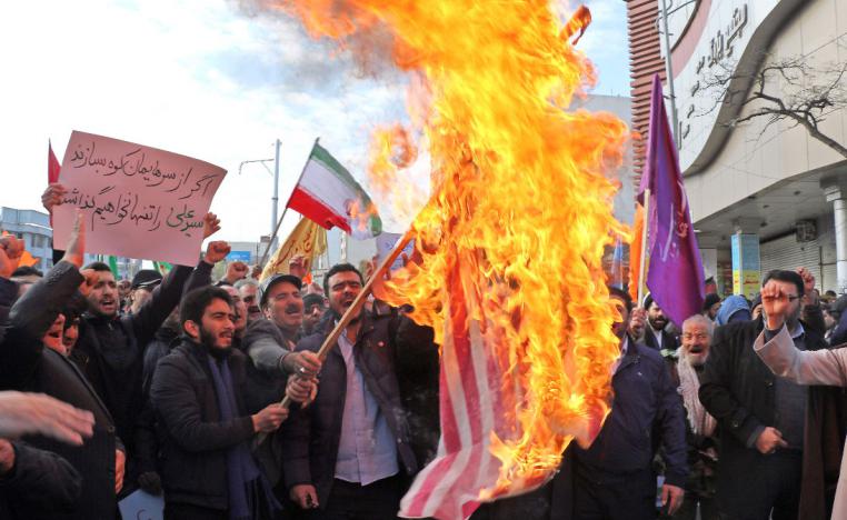 Iranians burn a US flag during a counter-protest in support of Iran's government