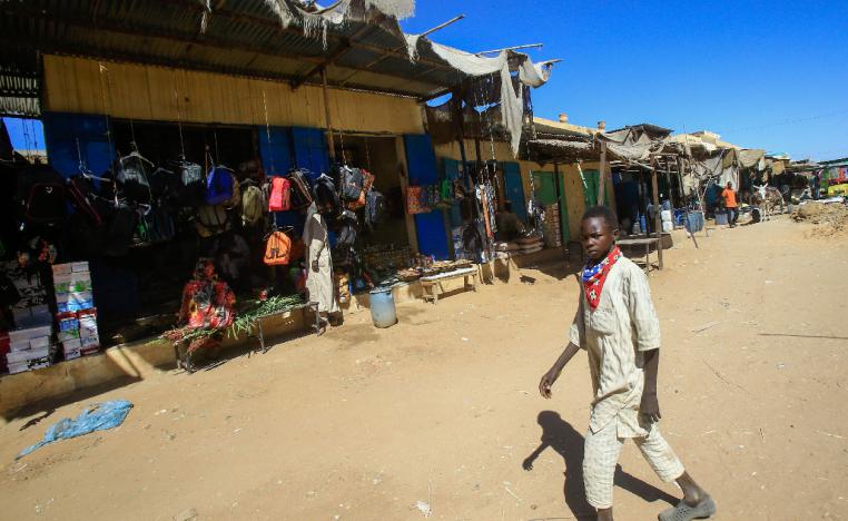 A diplaced Sudanese boy walks through the market of the Abu Shouk camp for internally displaced persons