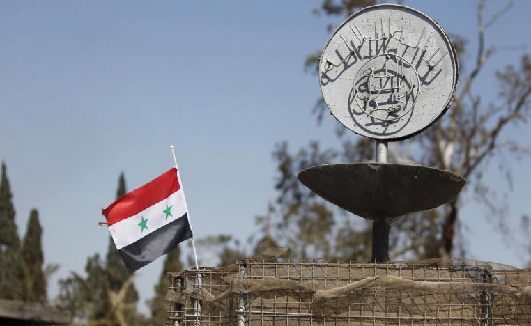 الجيش السوري يرفع علم بلاده بجانب شعار داعش