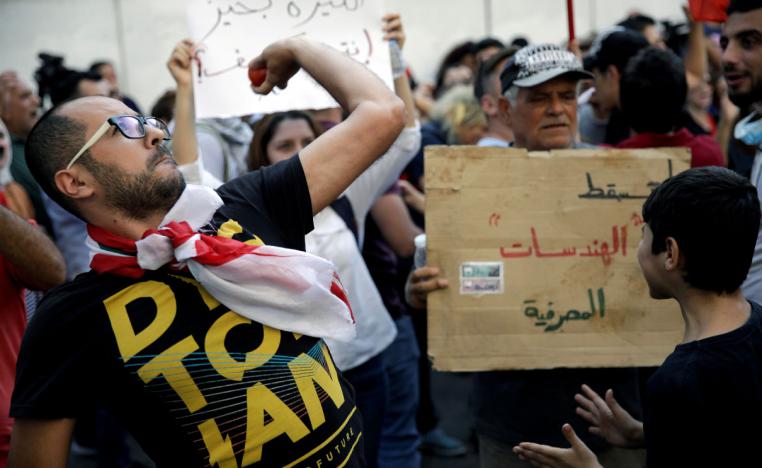 A protester throws a tomato at Lebanon's central bank during a demonstration in Beirut