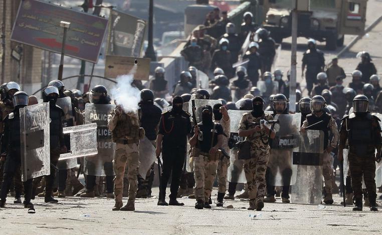 Iraqi riot police fire tear gas to disperse anti-government protesters gathering on the al- Shuhada (Martyrs) bridge