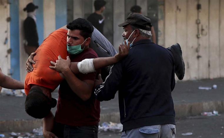 An injured protester is rushed to a hospital during clashes between Iraqi security forces and anti-government protesters in downtown Baghdad