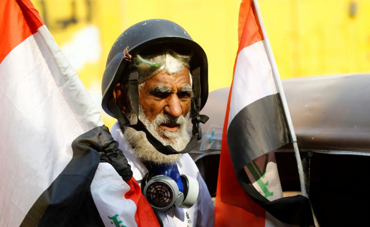A demonstrator holds the Iraqi flag during the ongoing anti-government protests in Baghdad