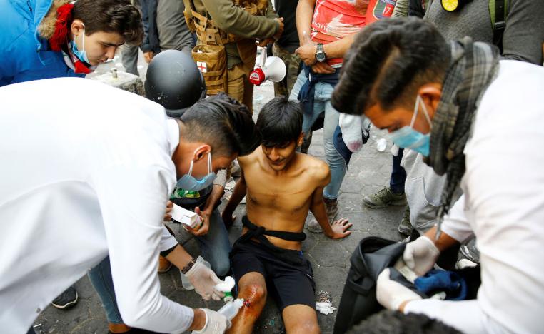 An Iraqi demonstrator receives medical attention during the ongoing anti-government protests