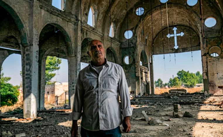 Sarkoun Selio walks in the ruins of the Assyrian Church of the Virgin Mary in the village of Tal Nasri
