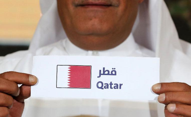 Hamed al-Hajri, a member of the Qatar Football Association, holds up the name of Qatar during the group draw for the 24th Arabian Gulf Cup