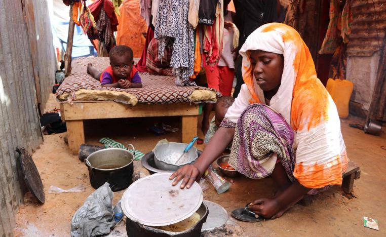 أم صومالية تطبخ لعائلتها وجبة متواضعة على النار