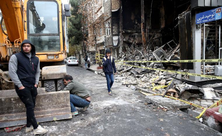 People walk near a burnt bank, after protests against increased fuel prices, in Tehran, Iran November 20, 2019
