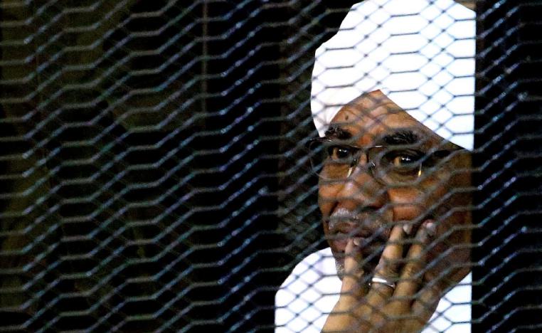Sudanese former president Omar Hassan al-Bashir sits inside a cage as he faces corruption charges in a court in Khartoum