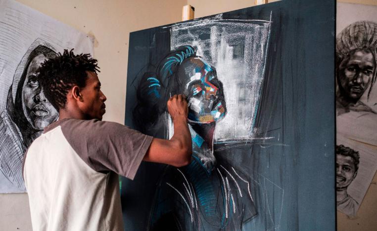Eritrean artist Nebay Abraha, 23, is pictured while working on a painting in his room and studio in Addis Ababa