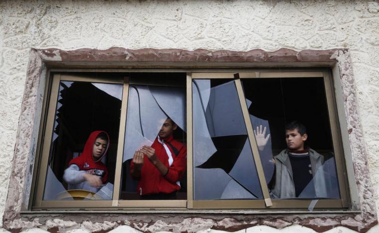 فلسطينيون في غزة يزيلون زجاج نوافذ محطم بعد غارة اسرائيلية قريبة