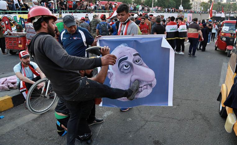 عراقيون يضربون تخطيطا لرئيس الوزراء العراقي المستقيل عادل عبدالمهدي