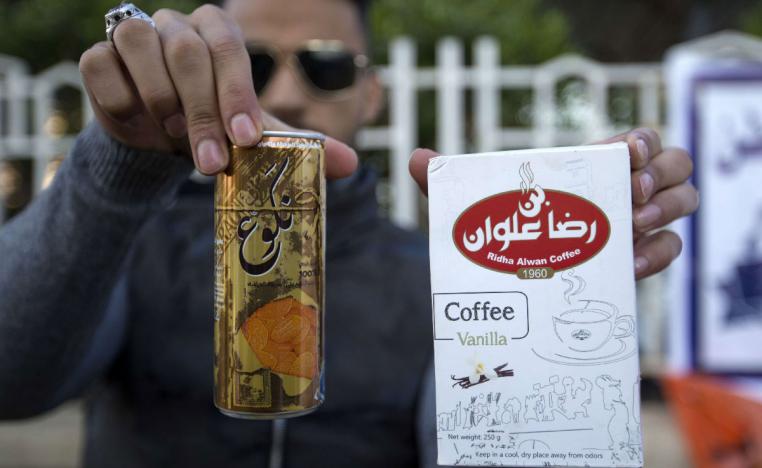 An Iraqi university student shows locally-made coffee and soft drink