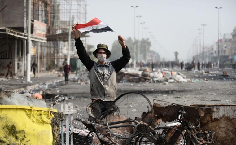 An Iraqi demonstrator carries the national flag in the southern Iraqi Shiite holy city of Najaf