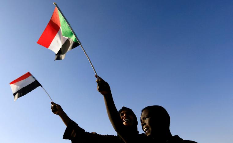 Sudanese civilians wave their national flag