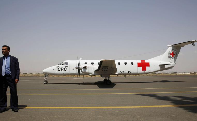 A Yemeni airport security official stands by a plane of the International Committee of the Red Cross