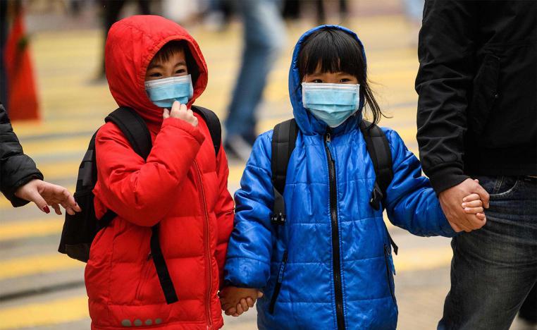 hildren wearing face masks cross a road during a Lunar New Year of the Rat public holiday in Hong Kong