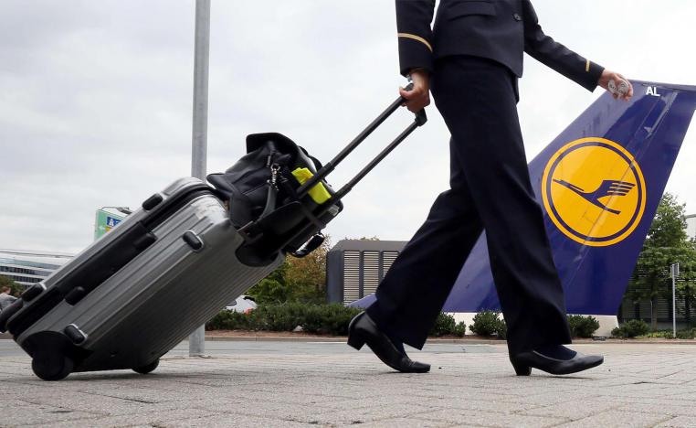 A flight attendant pulls his suitcase prior to a flight at the Lufthansa base of the Frankfurt airport
