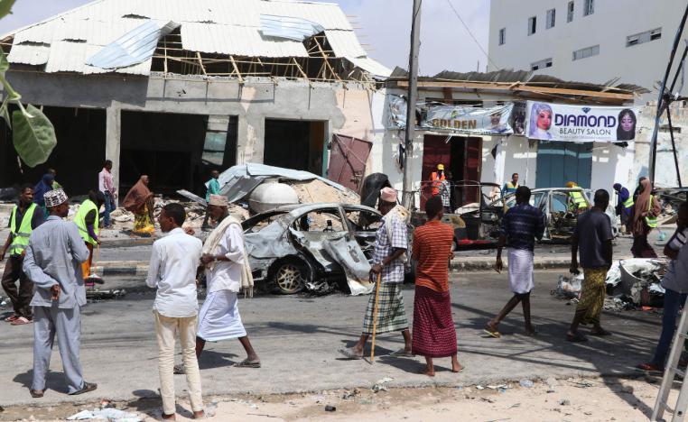 People gather at the site where a car bomb exploded near the Somali parliament in Mogadishu