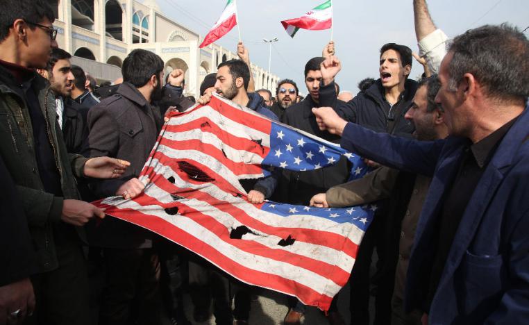 Iranians tear a US flag during a protest in Tehran