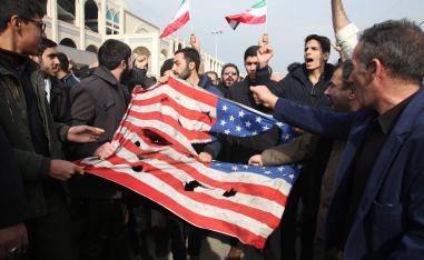 Iranians tear a US flag during a protest in Tehran