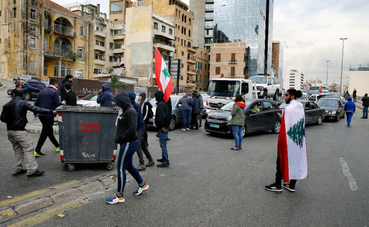 Anti-government protesters block a main highway using garbage containers in Beirut