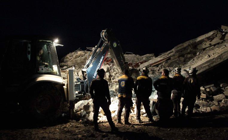 Members of the Syrian Civil Defence, also known as the White Helmets, search for survivors following an air-strike on the flashpoint town of Maaret al-Numan