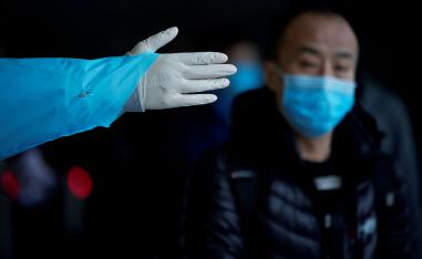 A passenger wearing a mask walks outside the Shanghai railway station in Shanghai, China