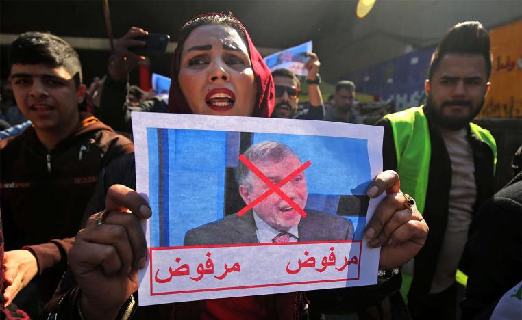 n Iraqi protester lifts pictures of the premier-designate Mohammad Allawi with the inscription "rejected"