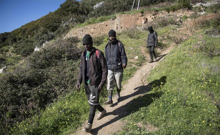 Guinean migrants walk near their hideout in the Belyounech forest, a few kilometres from Ceuta 