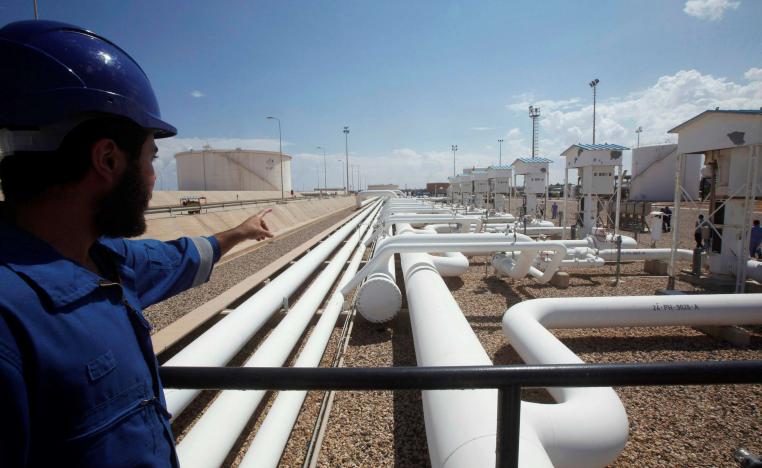 A worker gestures towards pipelines at the port and Zawiya Oil Refinery