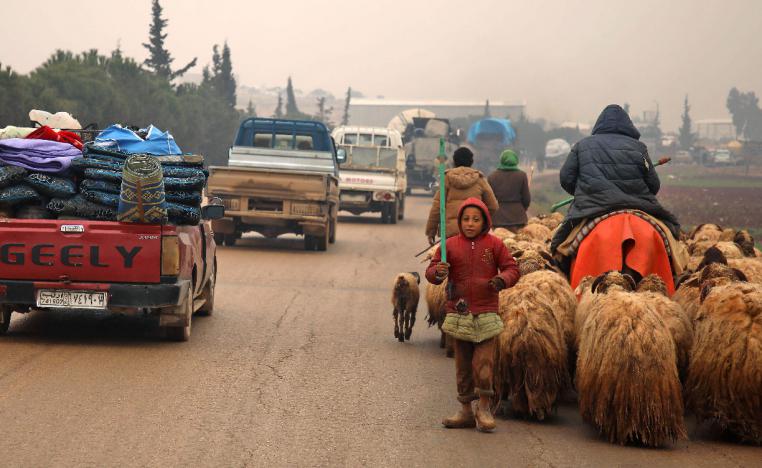 Syrians fleeing with their belongings on their way northwards toward the Turkish border