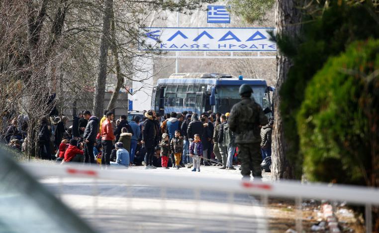 A group of asylum seekers wait in the no man's land between Turkey and Greece