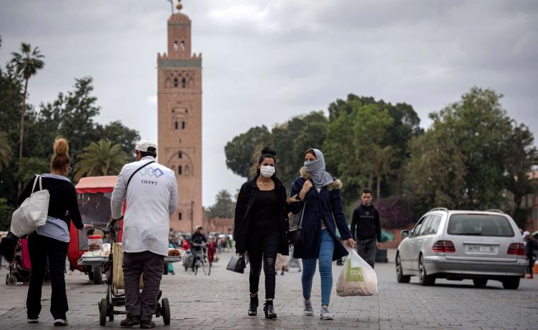 أشخاص يرتدون كمامات واقية يسيرون في ساحة جامع الفنا في مراكش