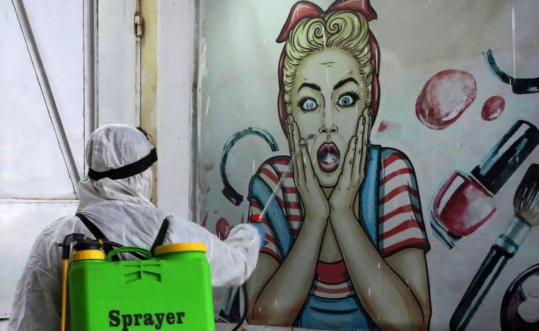 عامل من الصحة يرش حيطان بغداد بالمطهرات