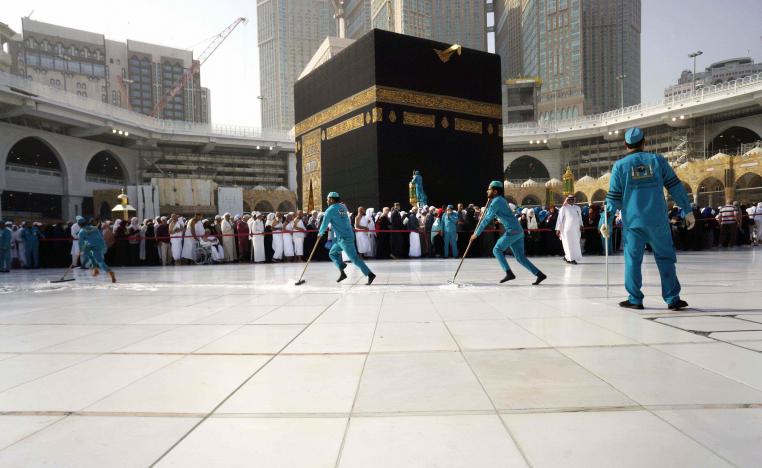 Workers sterilize the ground in front of the Kaaba