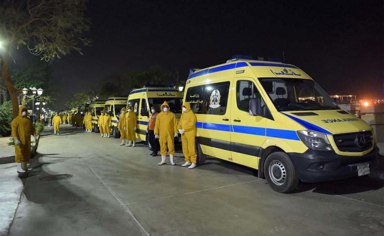 Egyptian health ministry emergency responders stand next to ambulances