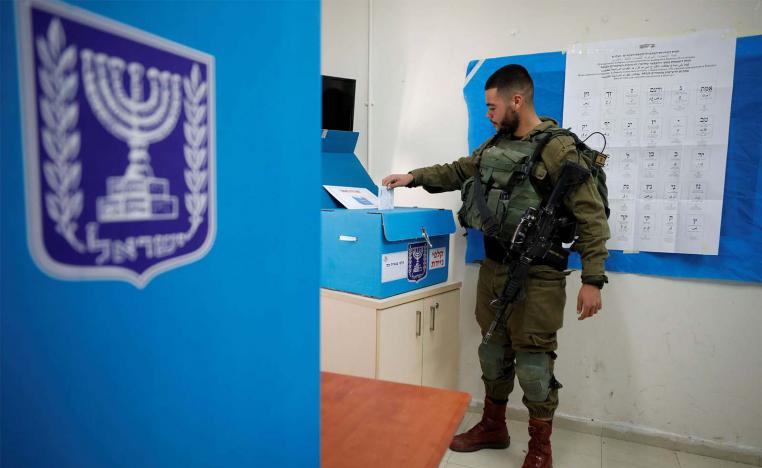 Israeli soldier casts his ballot as he votes in Israel's national election in a mobile polling station at a military post near Kibbutz Zikim