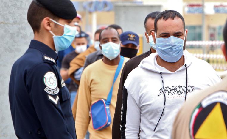 Expatriate workers arrive at a Kuwaiti health ministry containment and screening zone for COVID-19