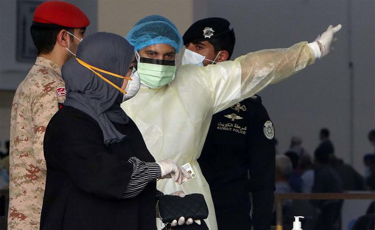 Kuwaiti healthy ministry workers prepare to scan expatriates living in Kuwait who returned from Egypt, Syria and Lebanon
