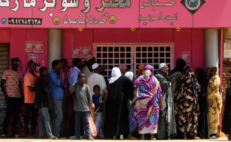 Sudanese people queue up outside a bakery in Omdurman