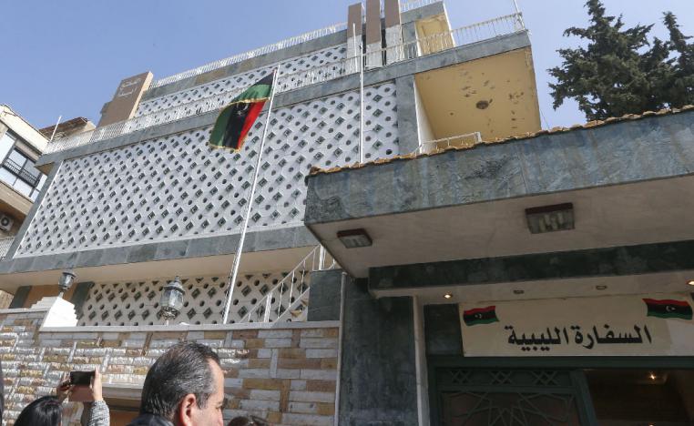 Reporters gather in front of the Libyan Embassy on the day of its reopening in Damascus