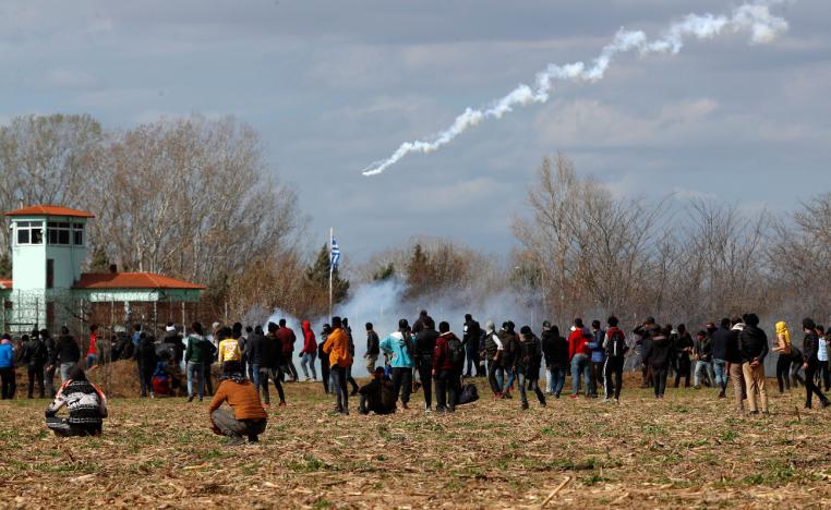 Migrants gather at a border fence on the Turkish side during clashes with the Greek riot police at the Turkish-Greek border in Pazarkule, Edirne region