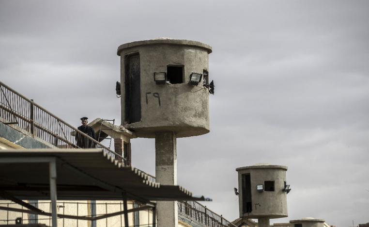 An Egyptian policeman stands near watch towers at Tora prison in Cairo