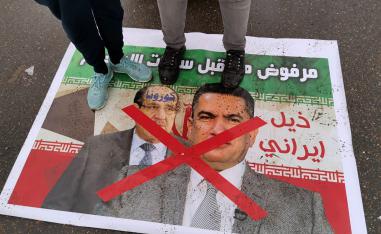 متظاهرون يدوسون على ملصقات لرئيس الوزراء المكلف عدنان الزرفي ورئيس الوزراء الأسبق نوري المالكي